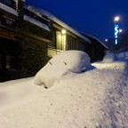 Car completely covered by snow in the main street of Arinsal